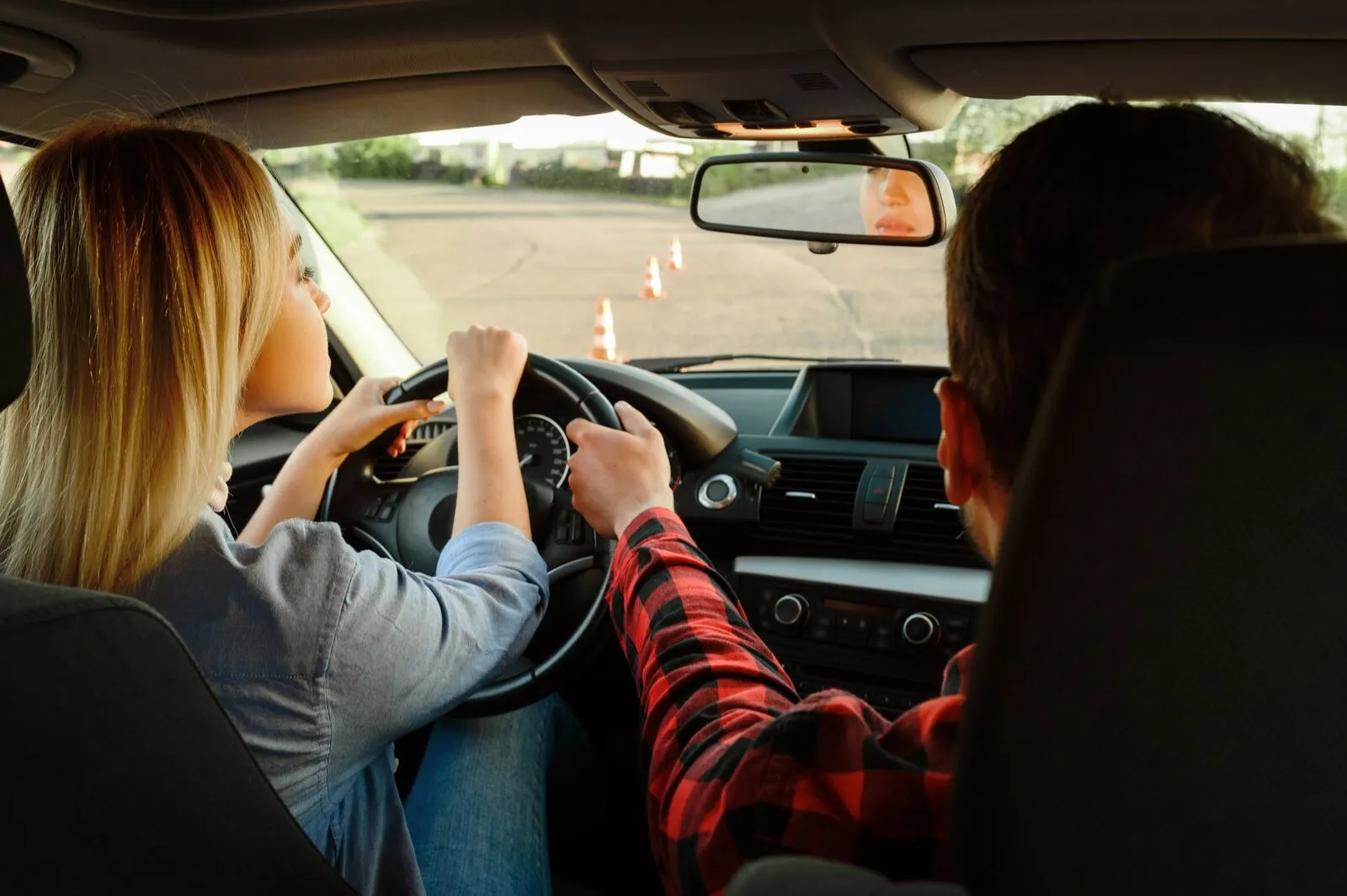 Driving instructor guiding a learner from the passenger seat